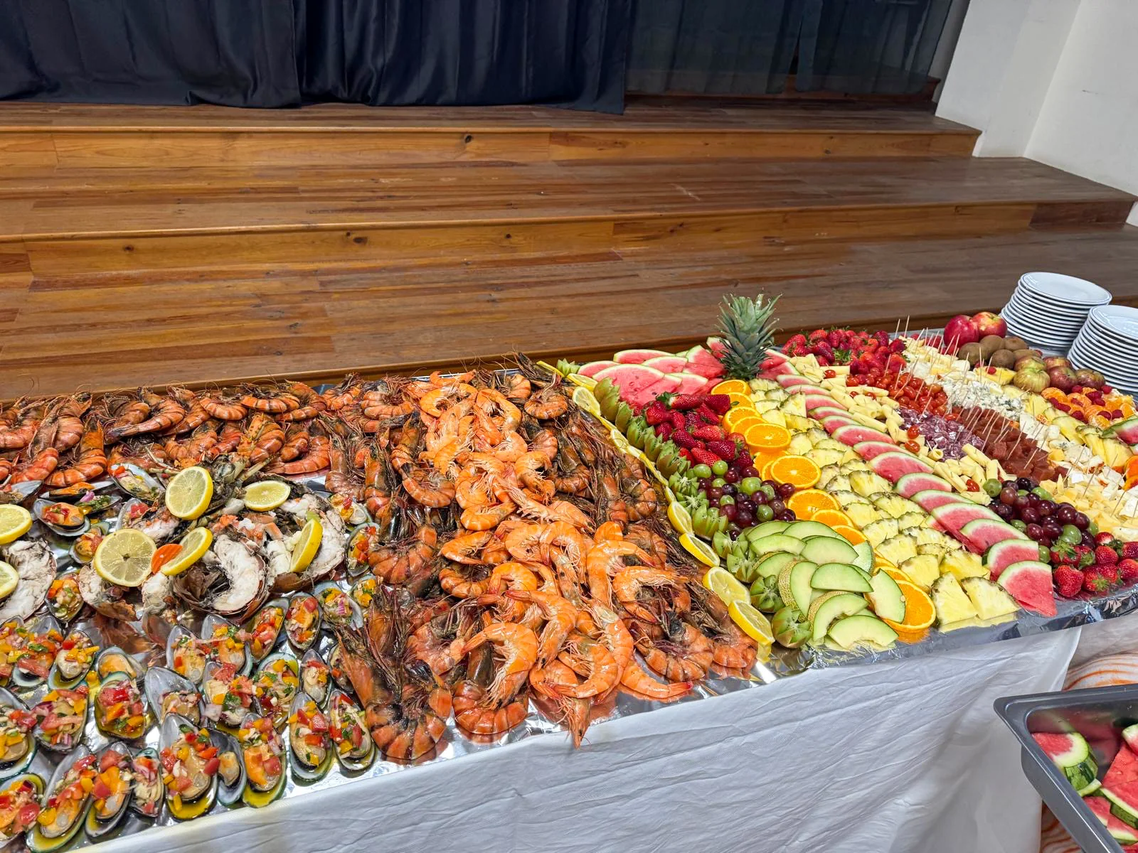 Mesa abundante com camarão, mexilhão, peixe e fruta fresca