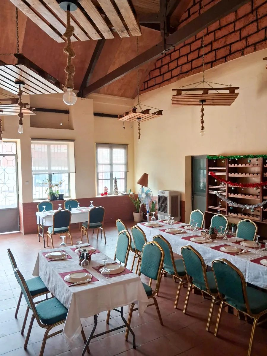 Sala preparada com mesas postas para receber convidados